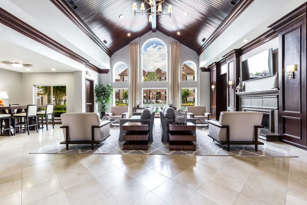 a large living room filled with furniture and a fireplace at Marquis on Park Row in Houston, TX.