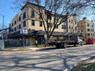 a truck is parked on the side of the road in front of a building .