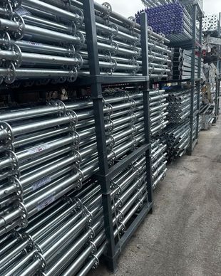 a row of metal pipes stacked on top of each other on shelves .