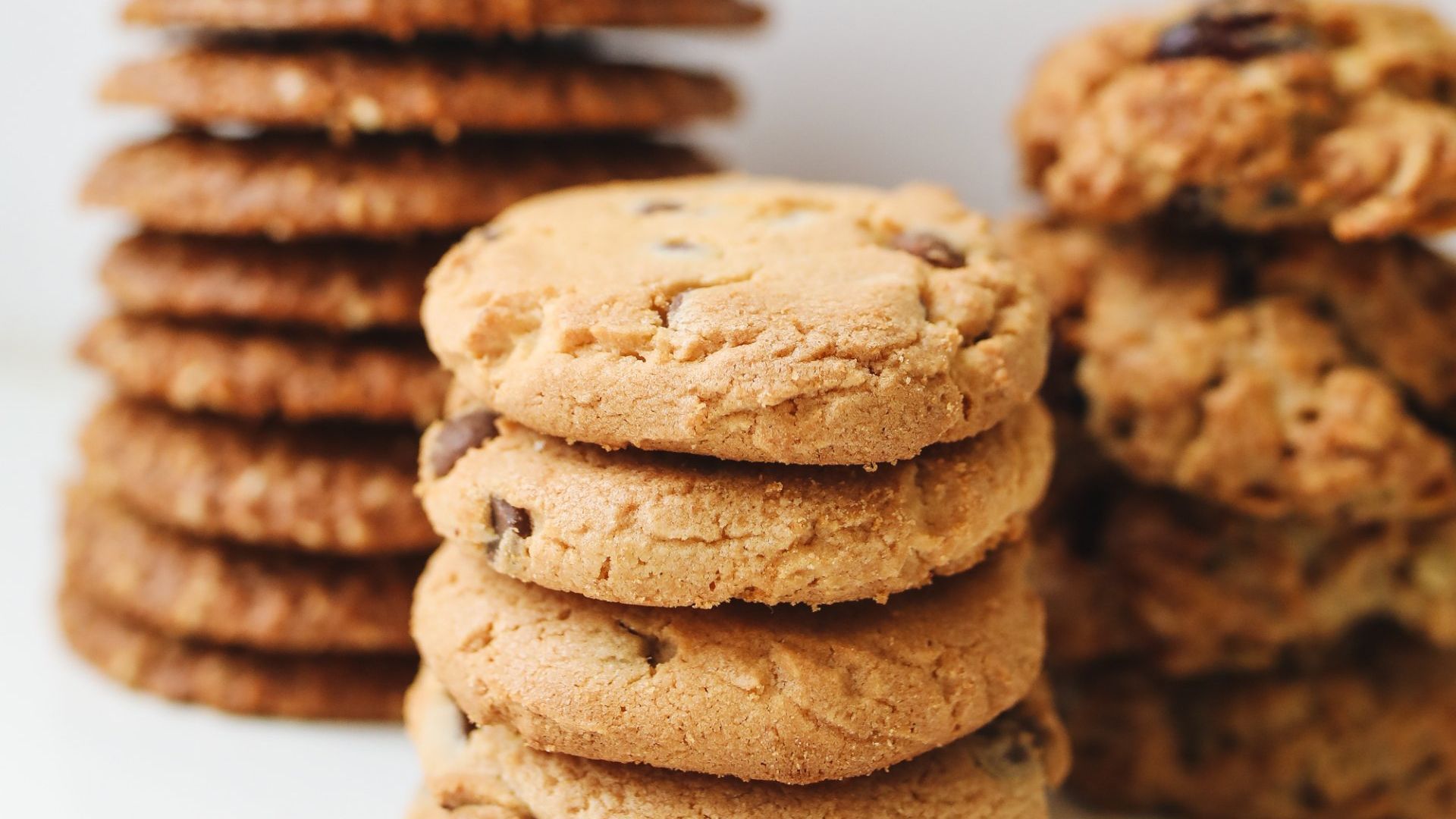 A close up of a stack of chocolate chip cookies on a table.