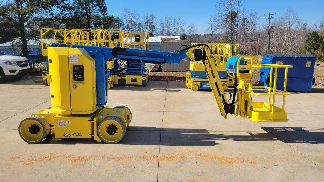 A drawing of a blue and yellow aerial lift on a white background.