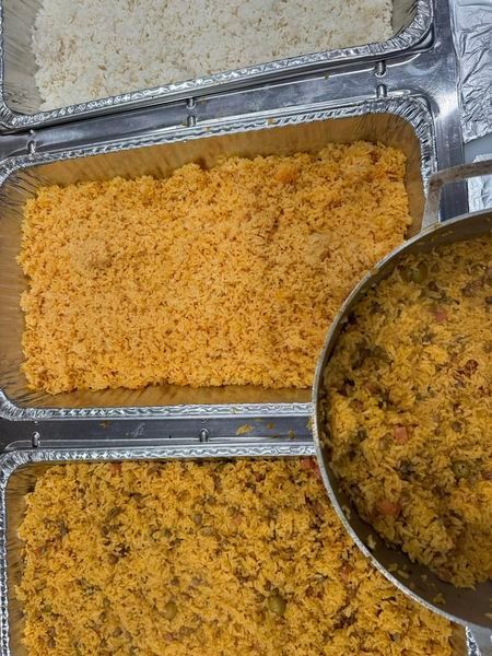 A pan of food is being poured into a pan of rice.