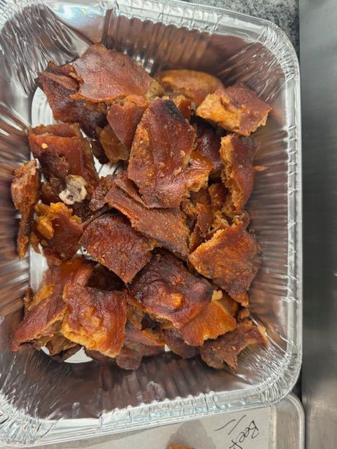 Aluminum foil container filled with fried pork chops on a table.