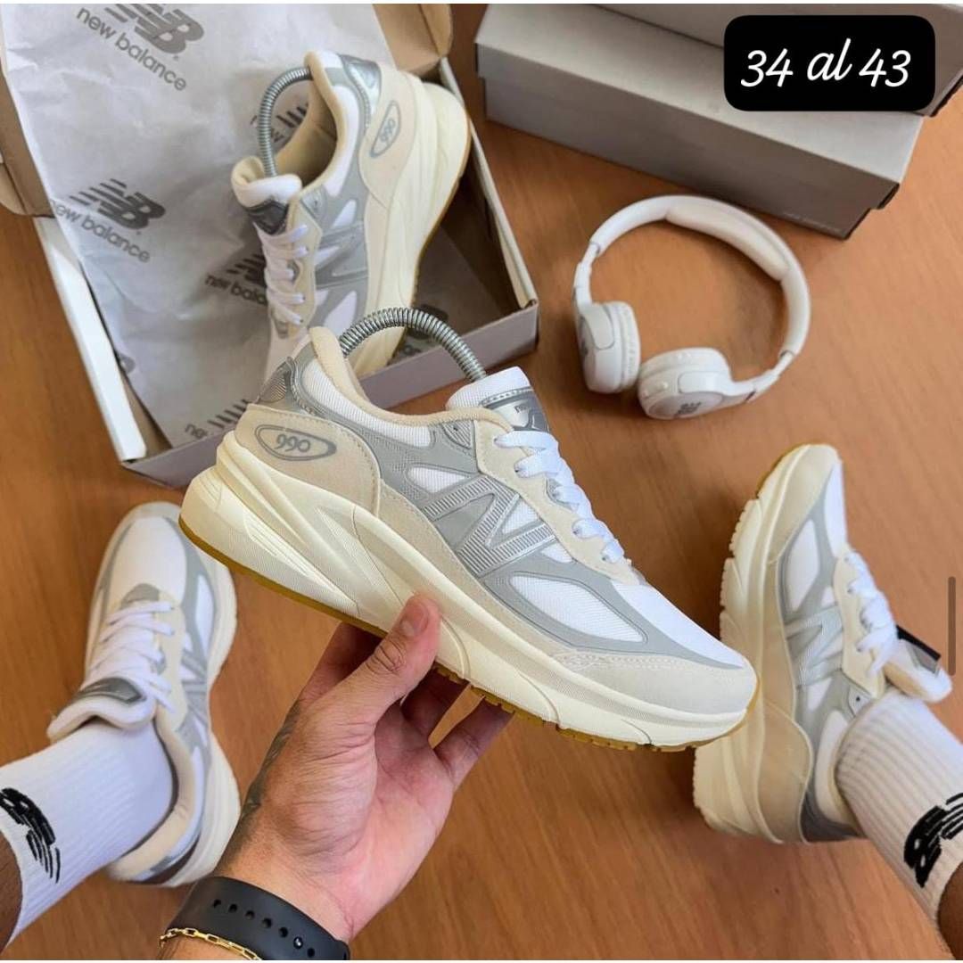 Una persona lleva un par de zapatillas blancas New Balance.