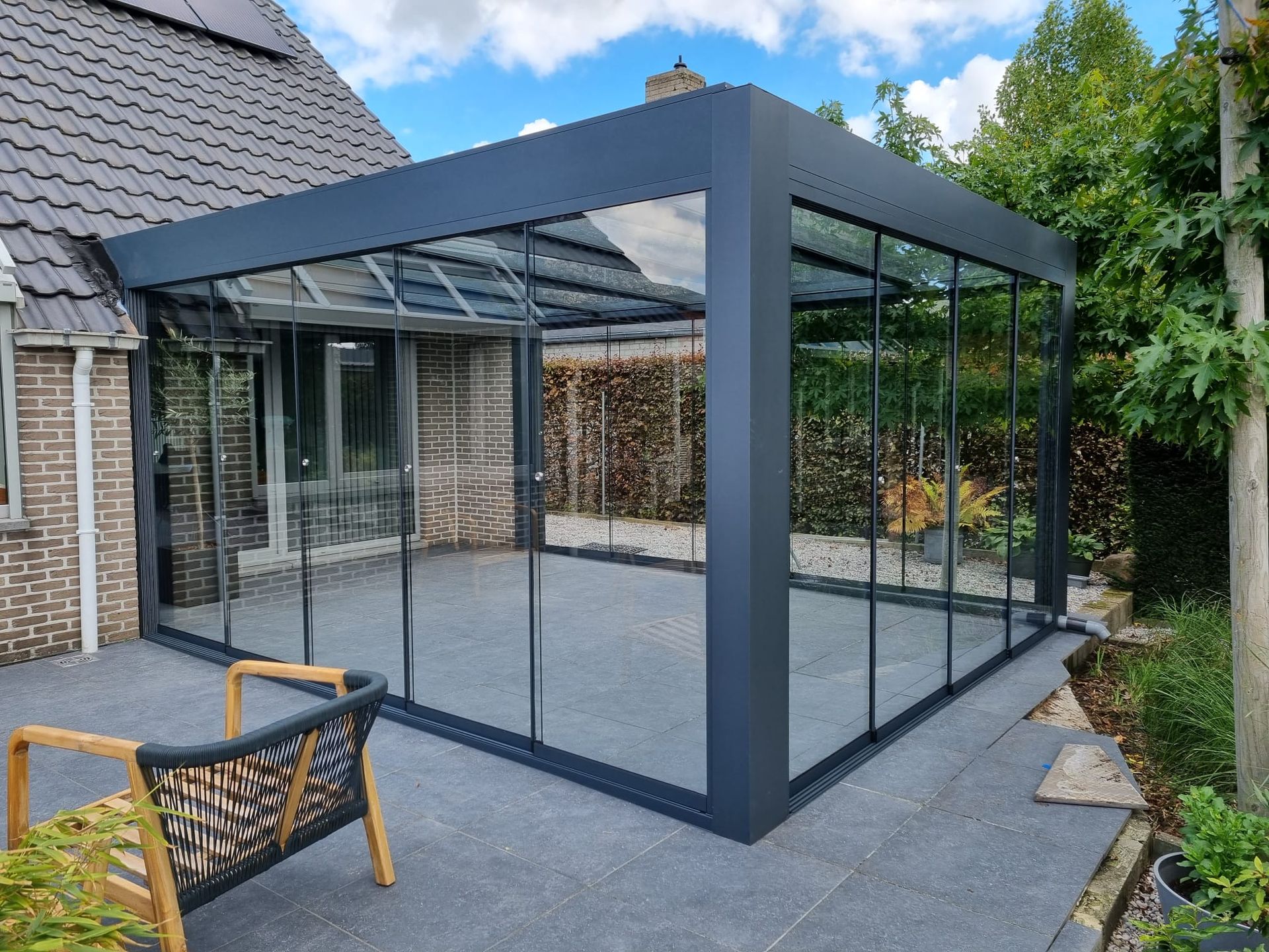 Een terras met een glazen schuifdeur en een stoel voor een huis.