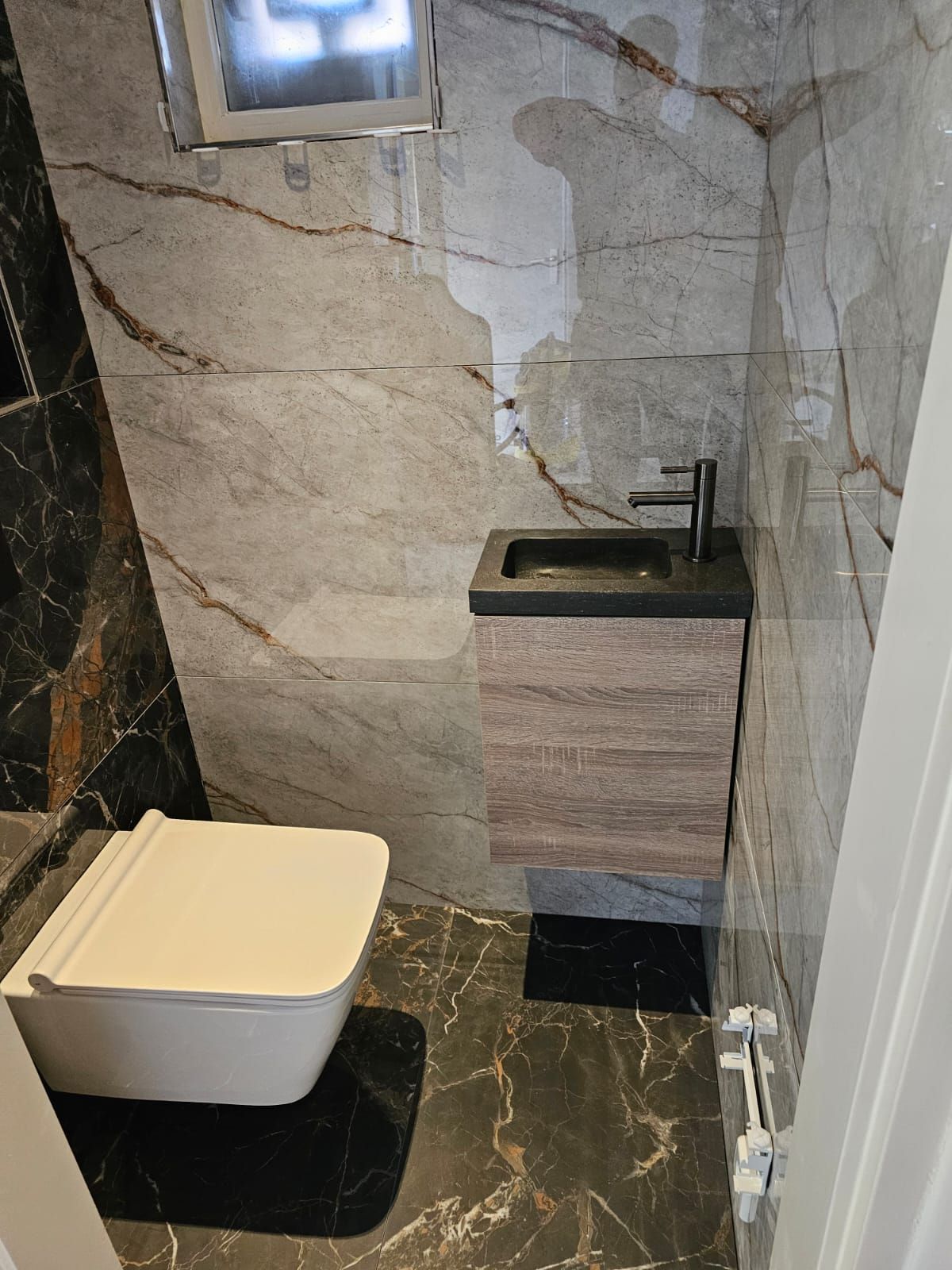 Een badkamer met toilet, wastafel en spiegel