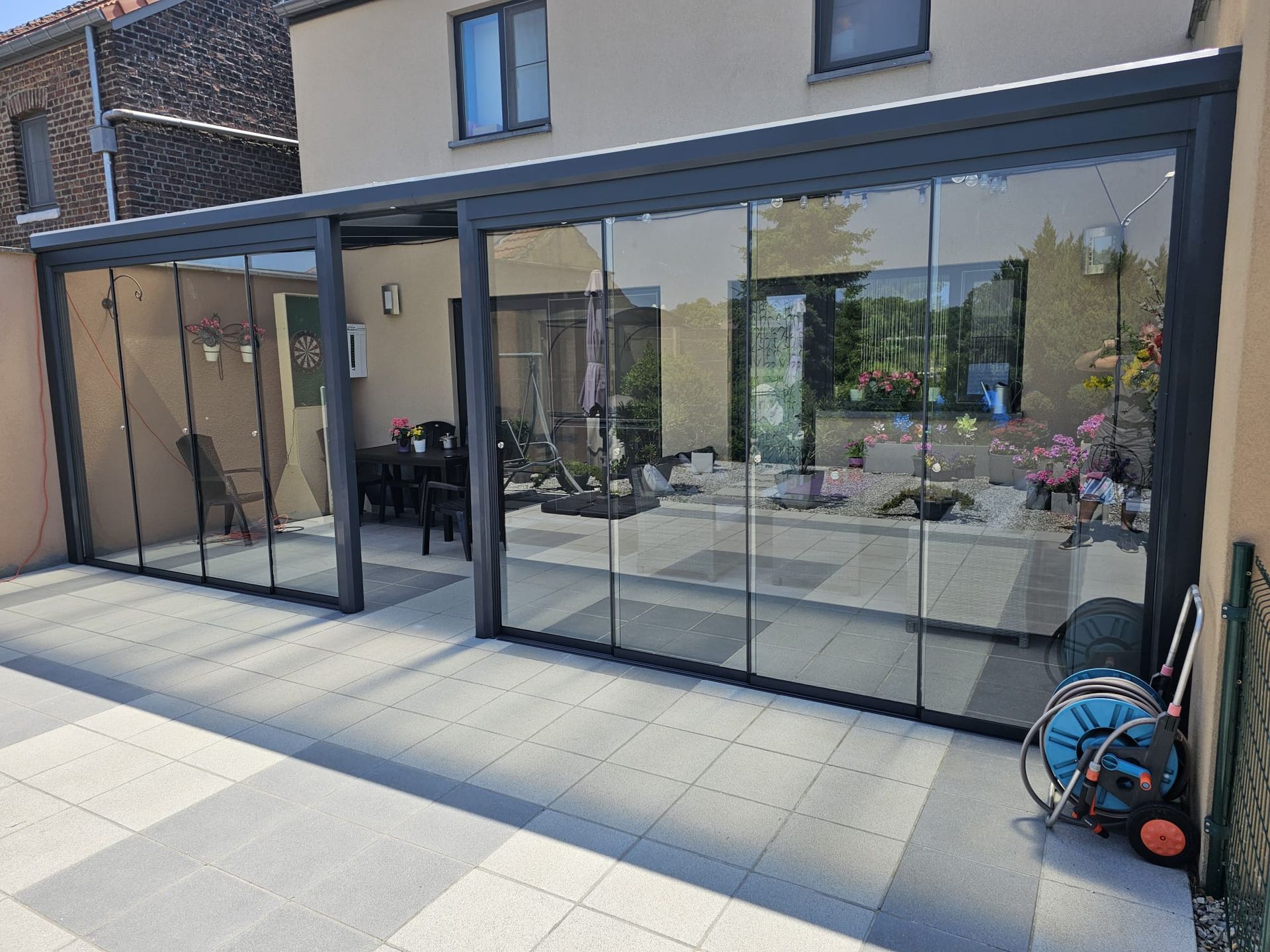 Een patio met glazen schuifdeuren die naar een huis leiden.
