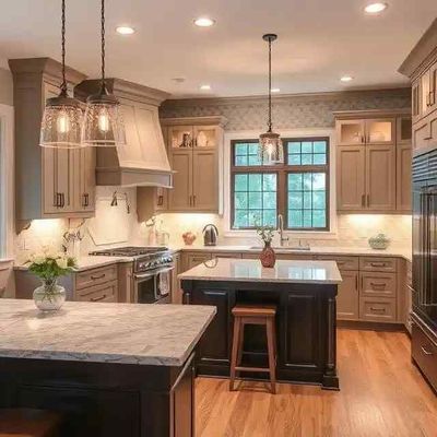 A well-lit, neutral-toned kitchen with a dark island, light countertops, wooden floor, and recessed lighting.