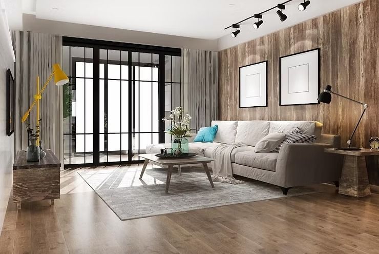 Living room with wood panel wall, light sofa, glass door, and framed art.