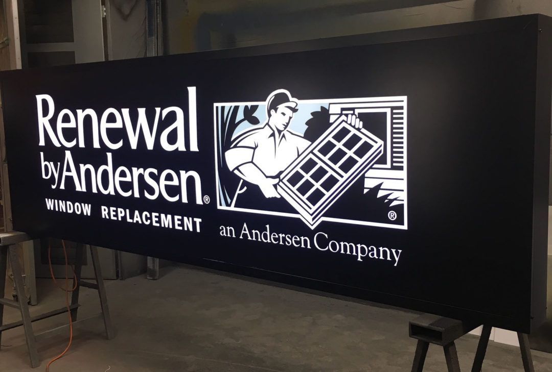 Black sign with white text and logo: