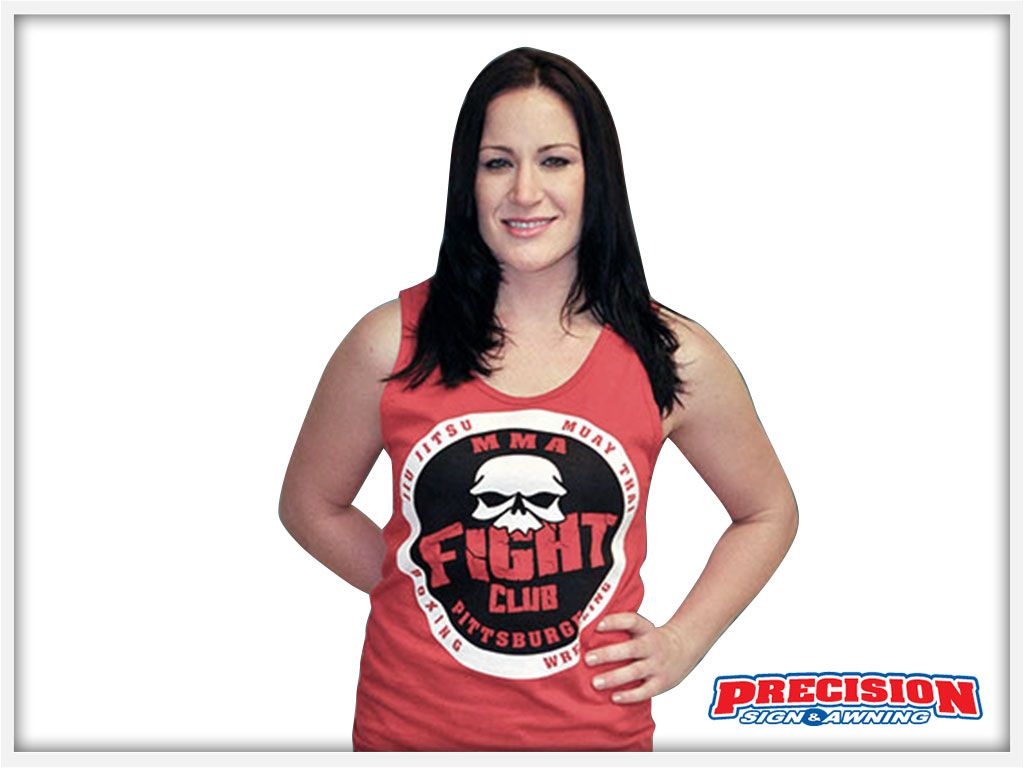 Woman in red tank top with a skull logo, standing in front of a white backdrop.