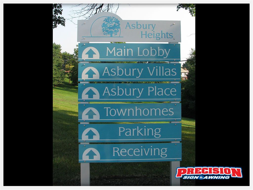Signpost for Asbury Heights. Blue and white, pointing to Main Lobby, Villas, Place, Townhomes, Parking, and Receiving.