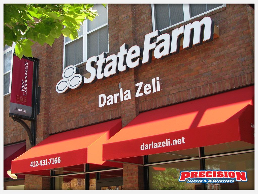 State Farm insurance office with red awnings and signage, brick building.