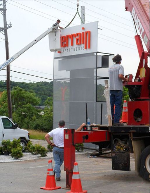 Workers installing a sign for
