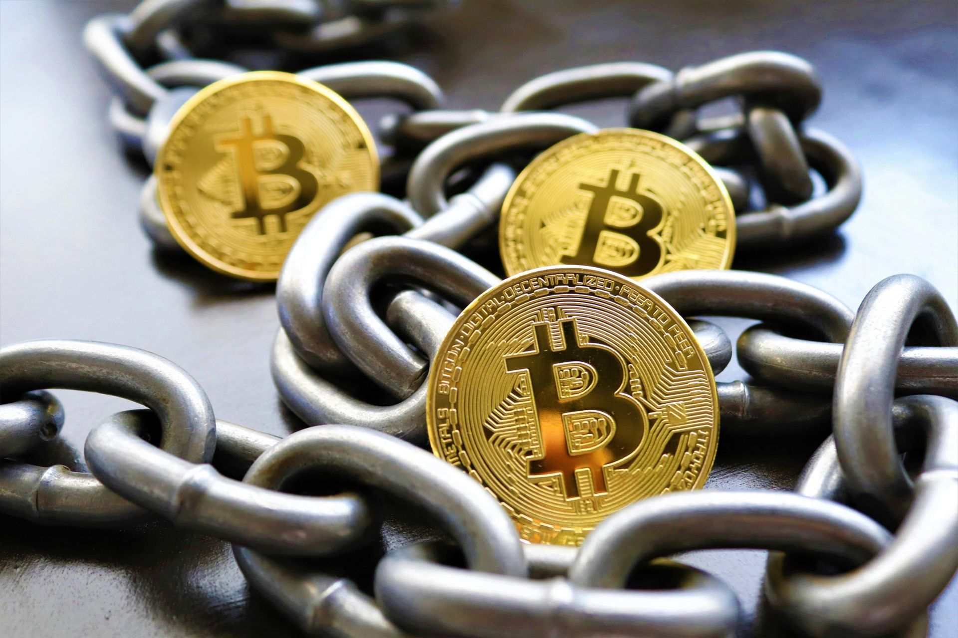 Gold Bitcoin coins on a silver chain.