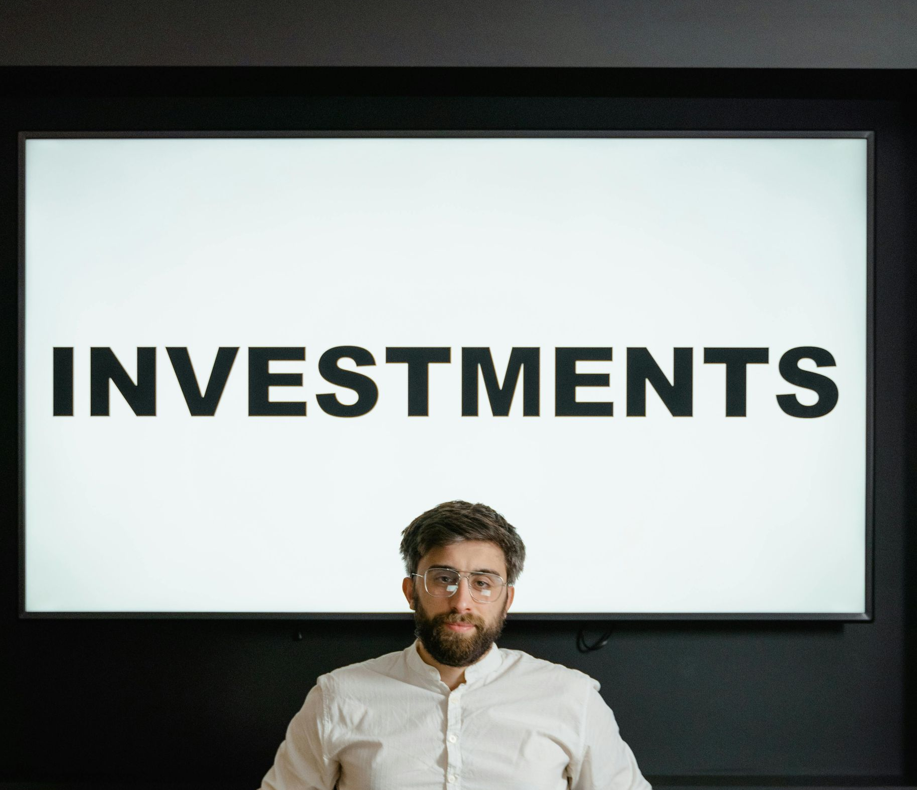 Man sitting in front of a screen displaying 