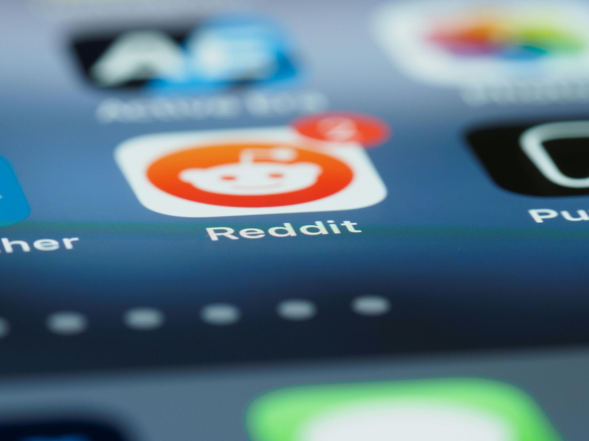 Reddit app icon on a phone screen, orange and white logo with notification badge.