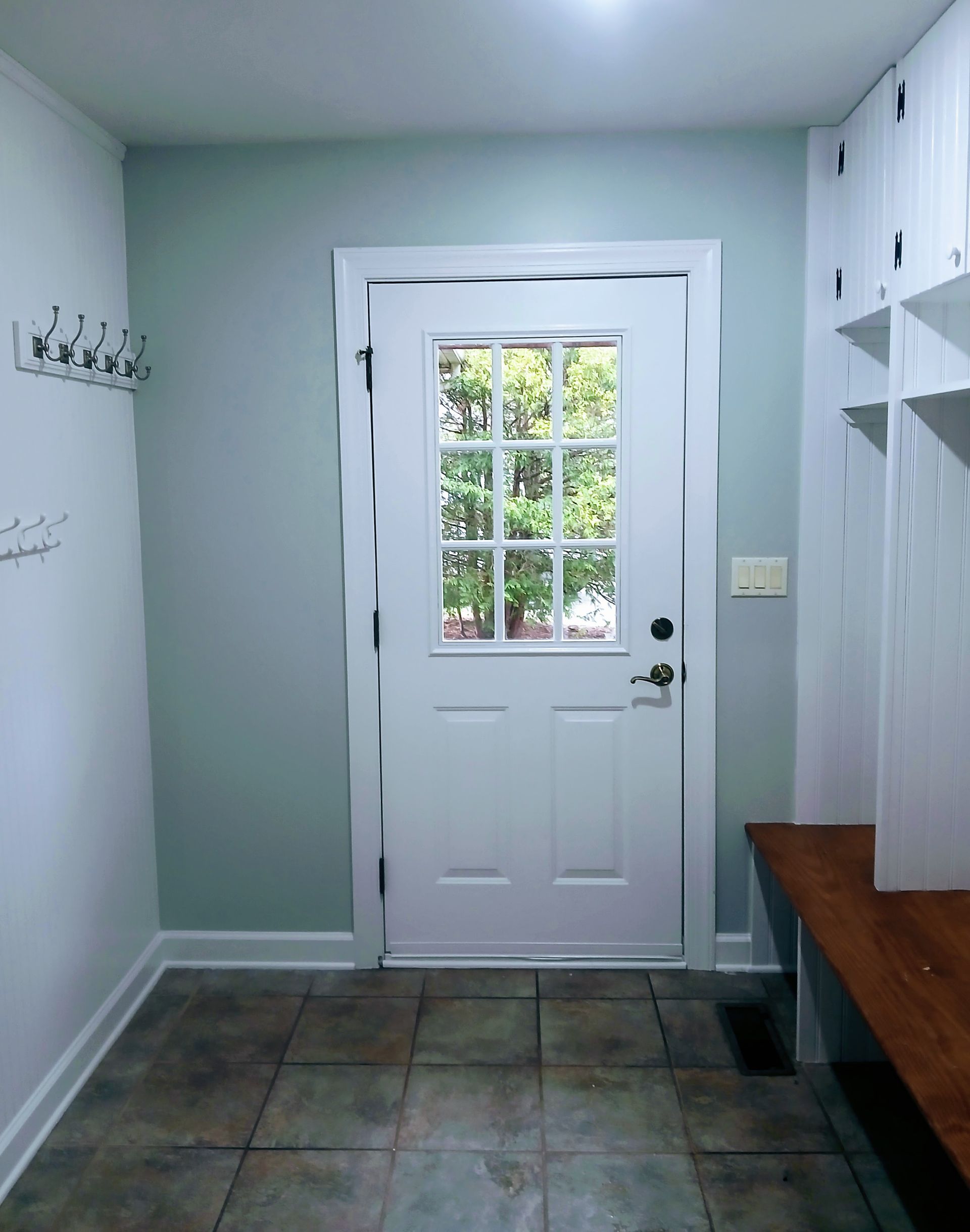 A hallway with a white door and a window