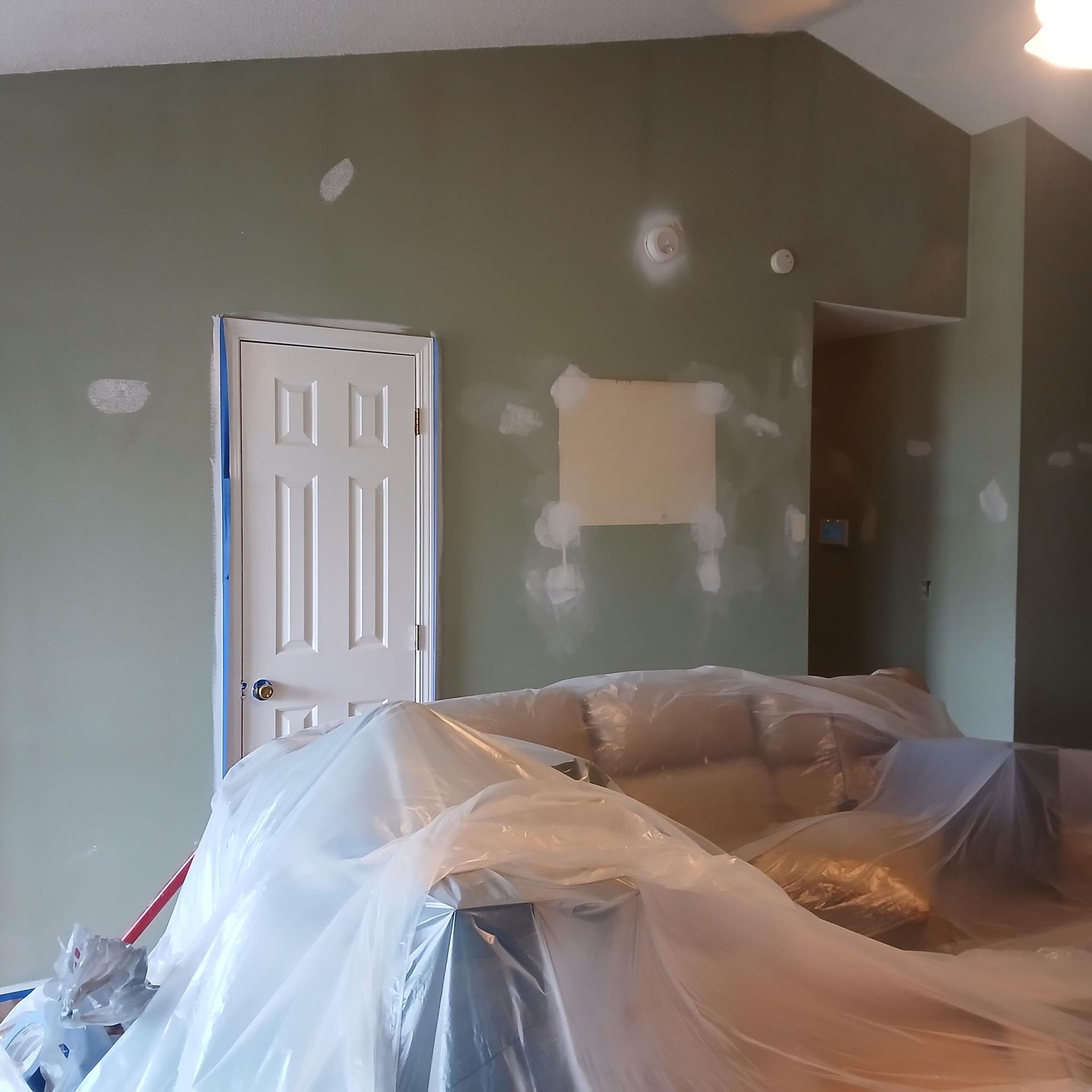 A white van is parked under a wooden structure