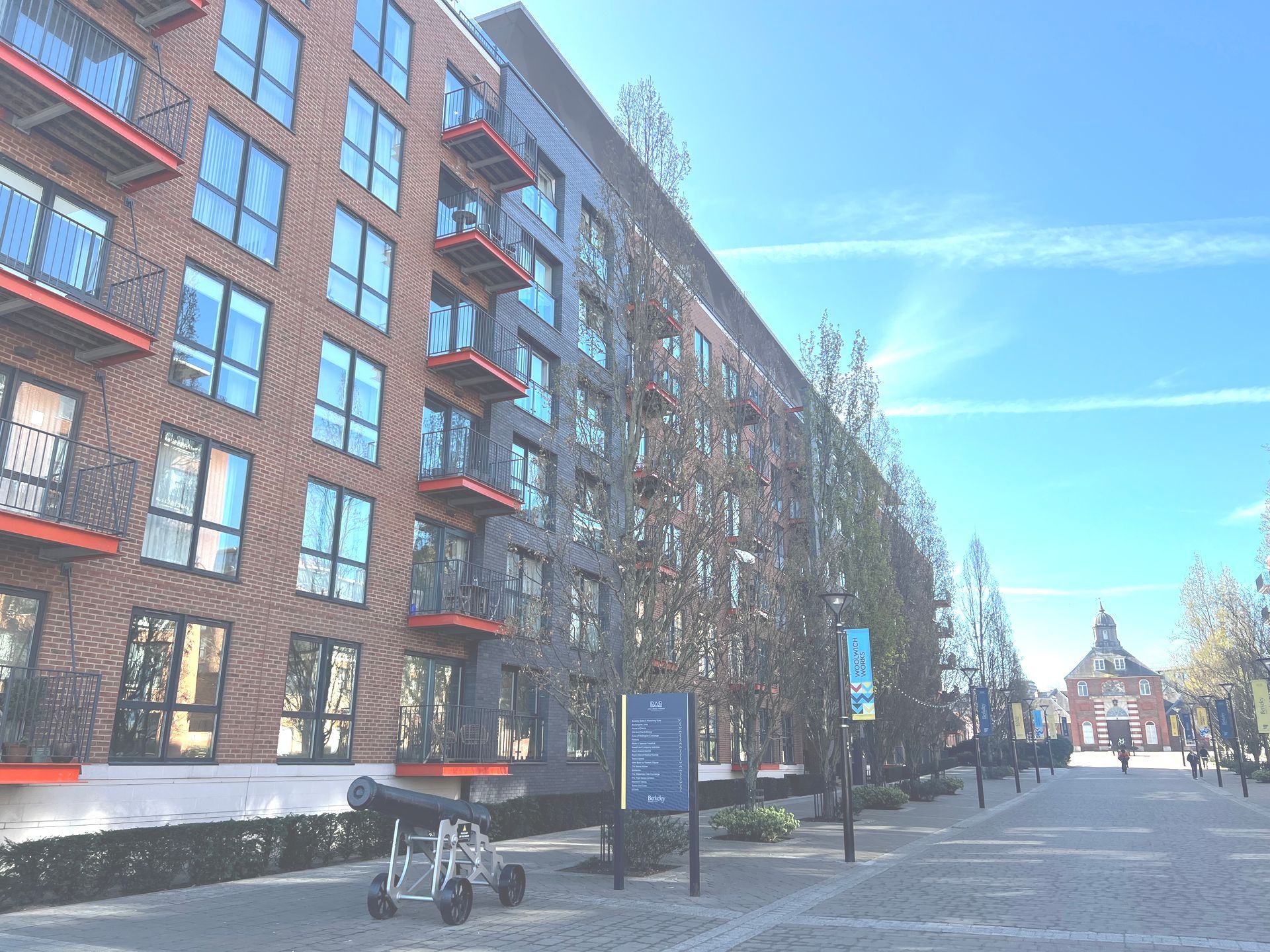 A large apartment building with a cannon in front of it.