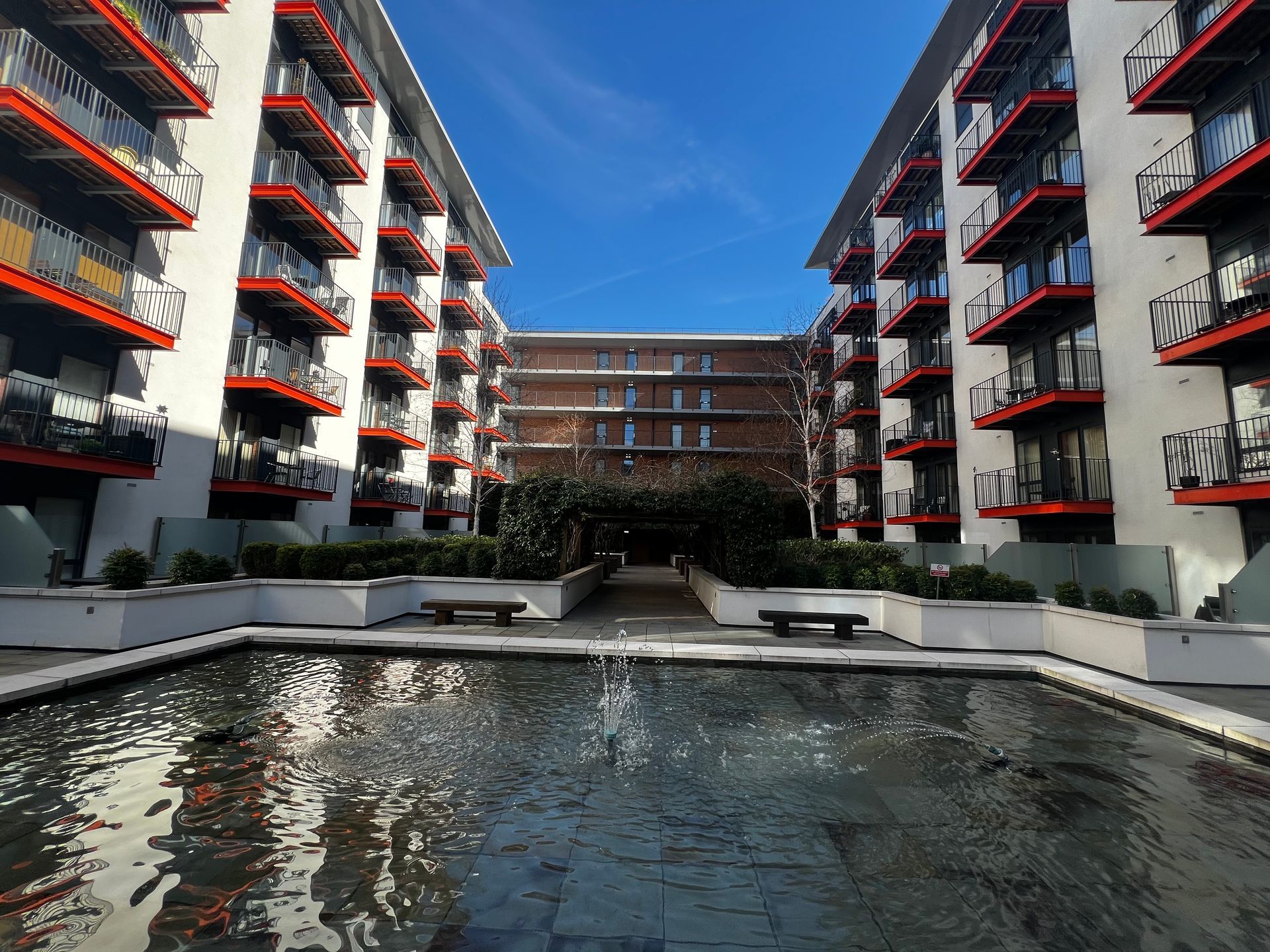 A large apartment building with a fountain in the middle