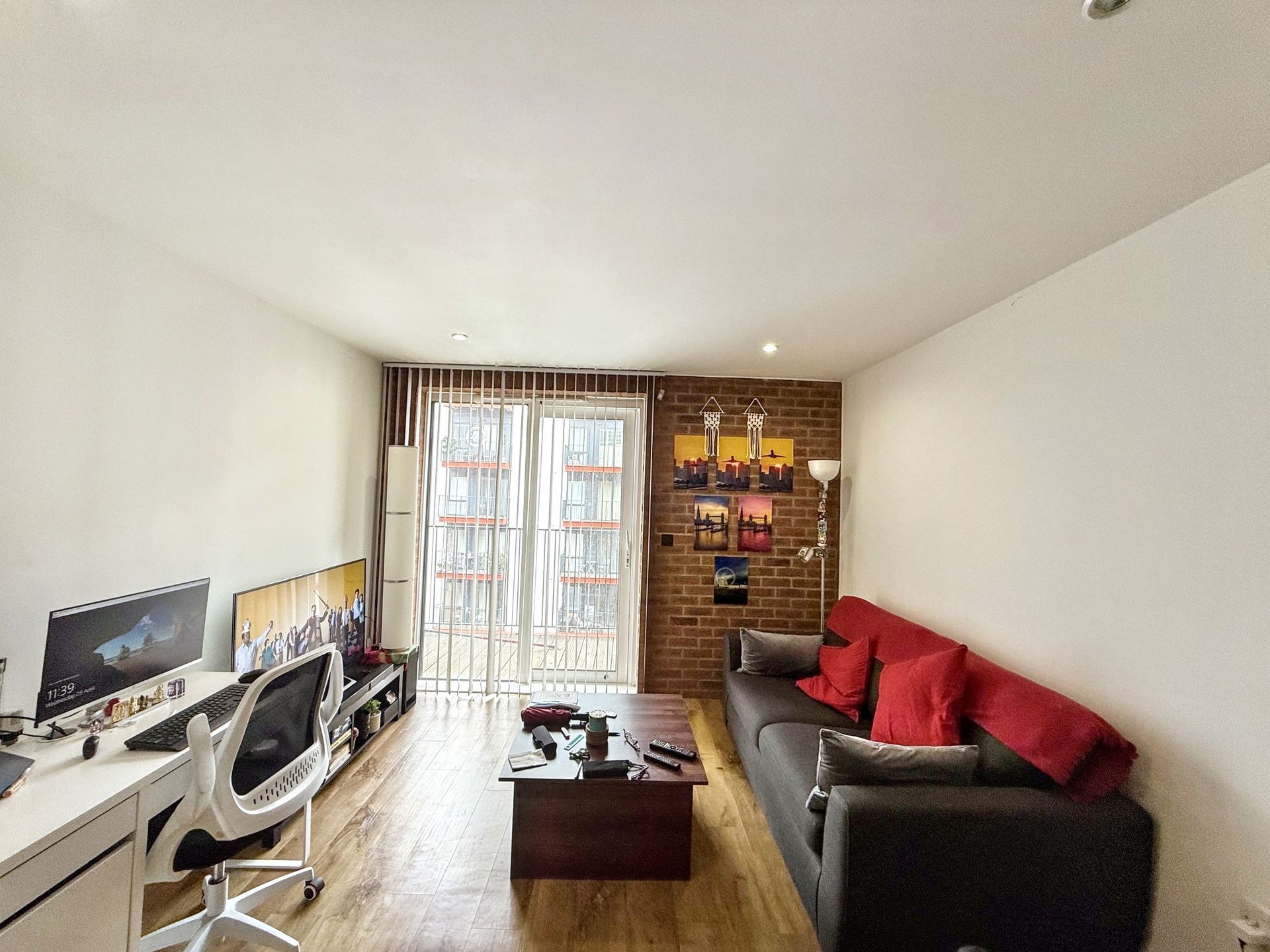A living room with a couch , desk and chair.