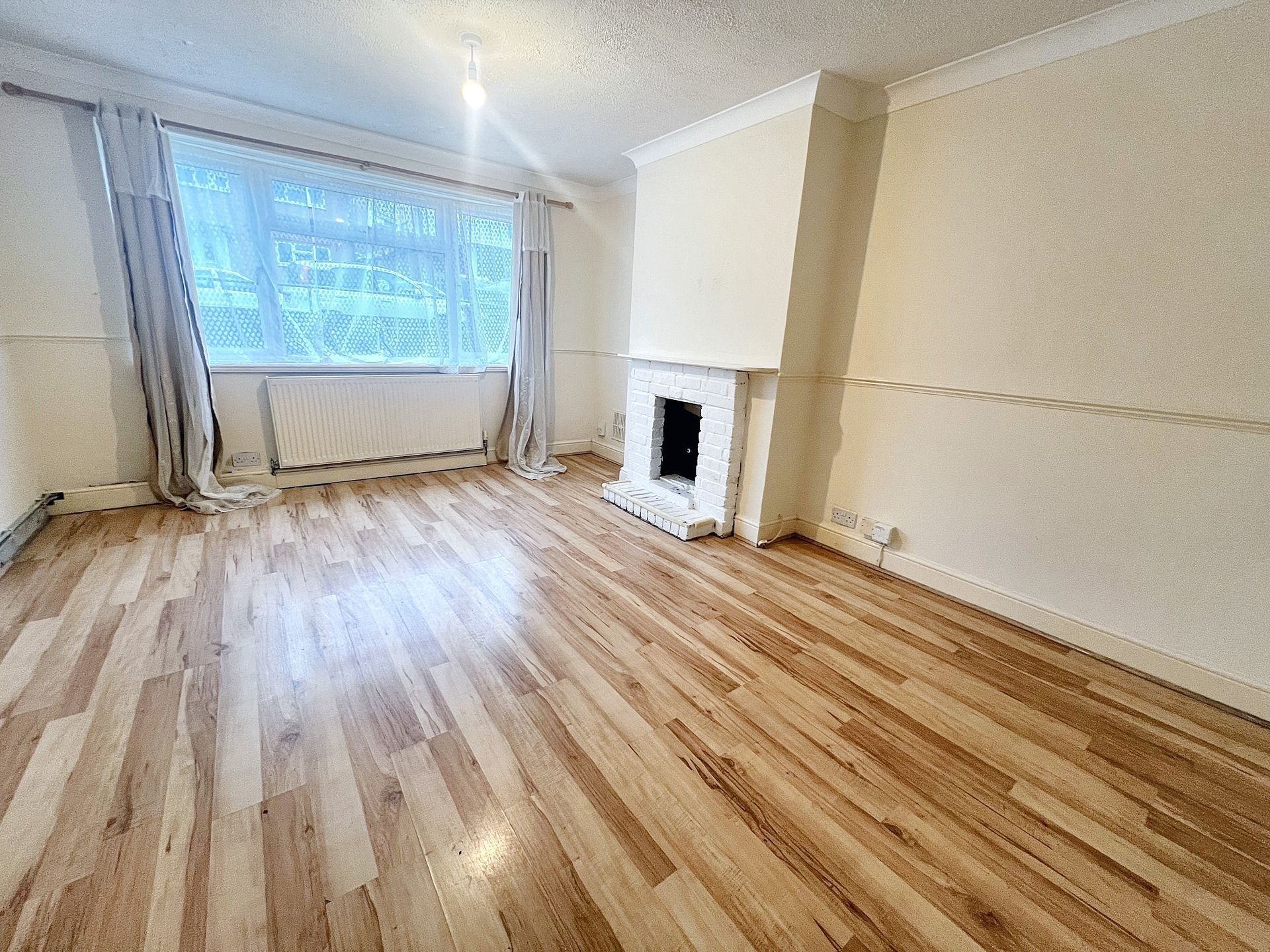 A living room with hardwood floors and a fireplace.