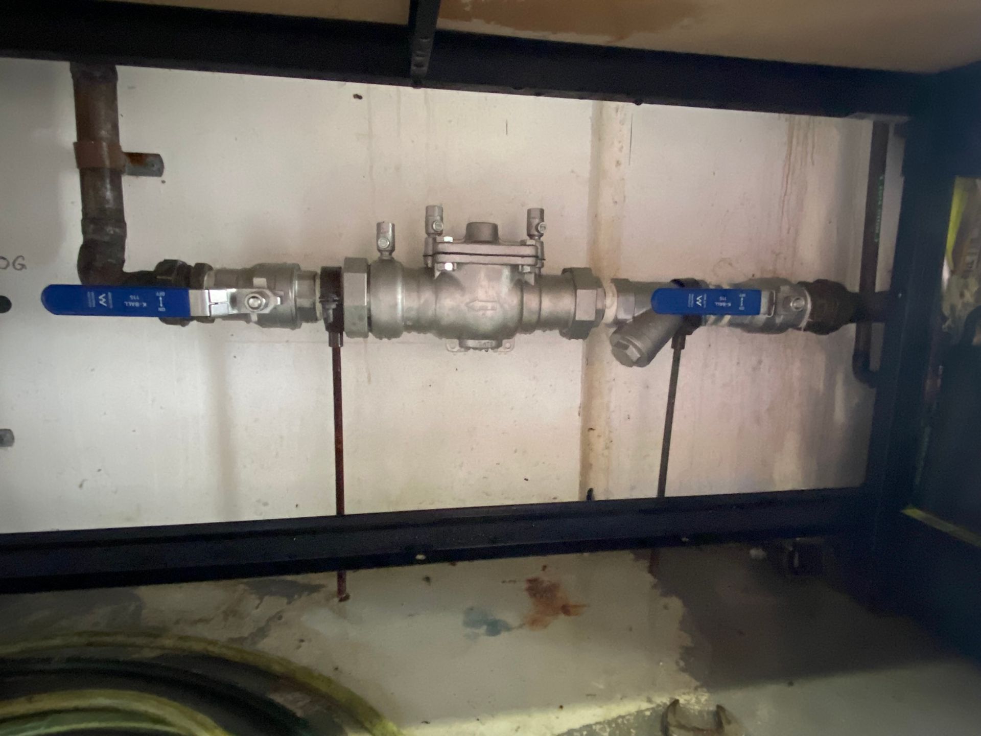 Valves And Blue-handled Pipe Fittings Inside A Utility Cabinet Under A Sink — Gibson Plumbing & Roofing Pty Ltd in Boyne Island, QLD