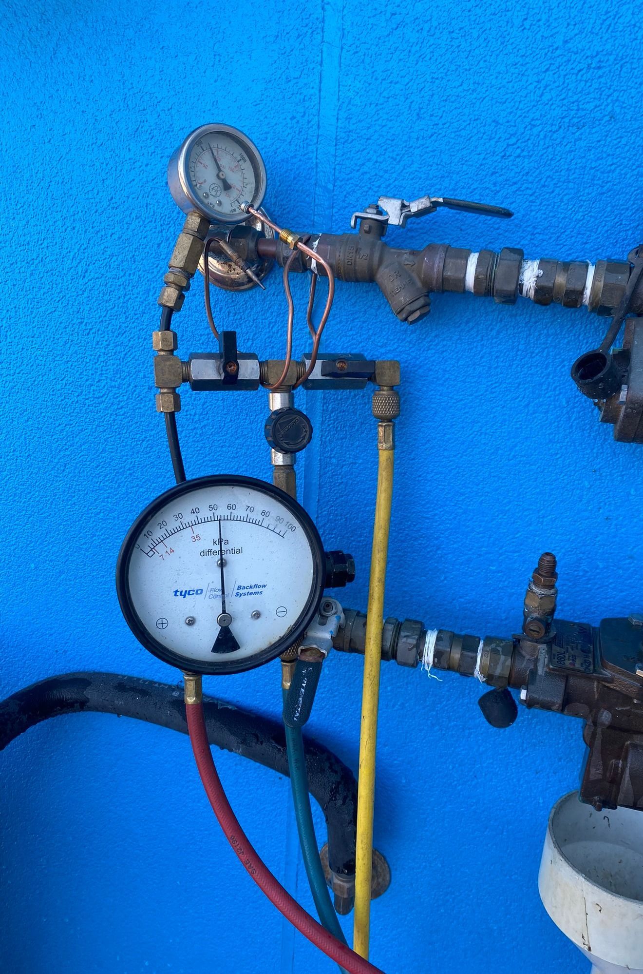 Pressure Gauges On Pipes Against A Bright Blue Wall — Gibson Plumbing & Roofing Pty Ltd in Boyne Island, QLD