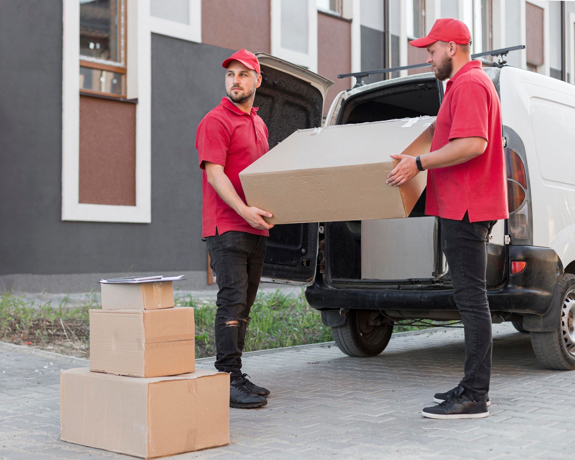 Two delivery men are loading boxes into a van.