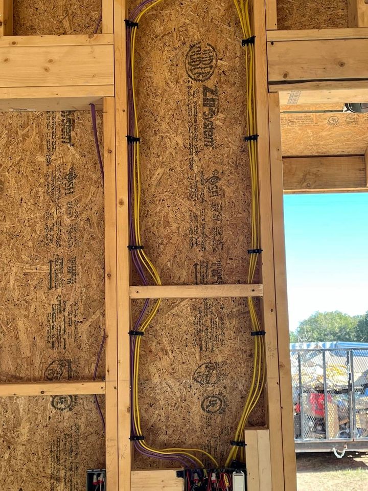 A wooden wall with electrical wires coming out of it.