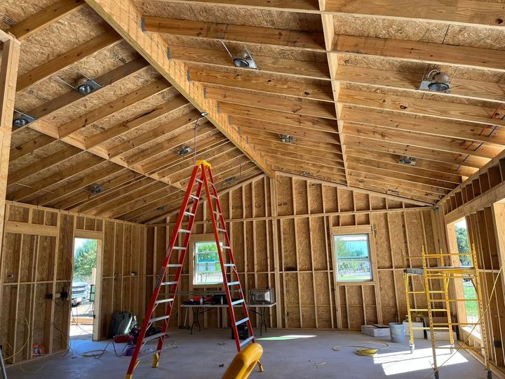 A ladder is sitting in the middle of a room under construction.