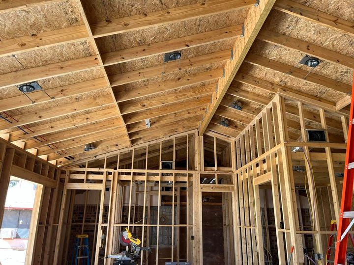 The inside of a house under construction with a ladder in the foreground.
