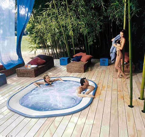 Un couple de personnes sont assis dans un bain à remous sur une terrasse