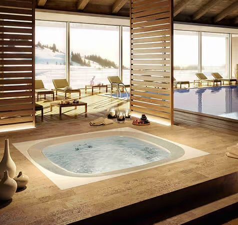 Un jacuzzi est posé sur un sol carrelé à côté d'un palmier.