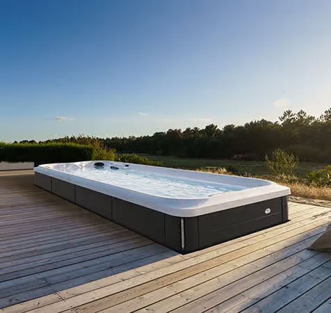 Une grande piscine est située au sommet d'une terrasse en bois.