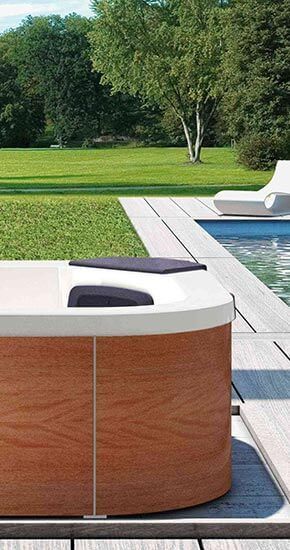 Un bain à remous en bois est installé à côté d'une piscine.