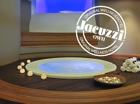 Un jacuzzi dans une chambre d'hôtel avec serviettes et bougies.
