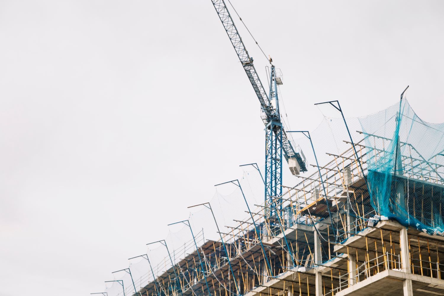 Se está construyendo un gran edificio con una grúa al fondo.