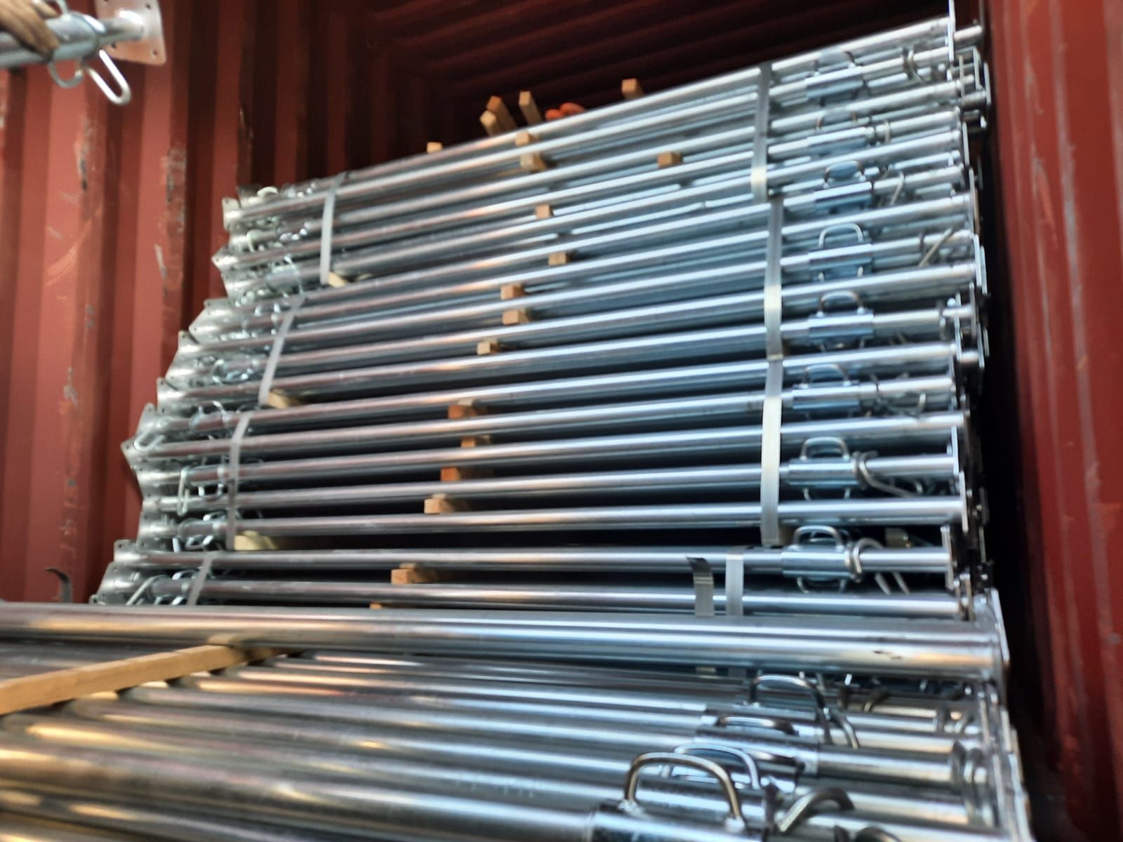 Una pila de puntaes metálicos dentro de un contenedor rojo.