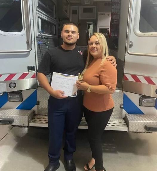 A man and a woman standing in front of an ambulance