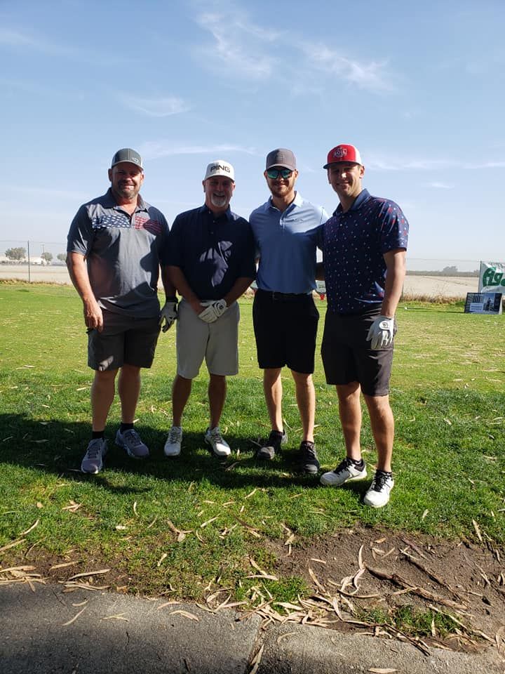 A group of men are posing for a picture on a golf course.