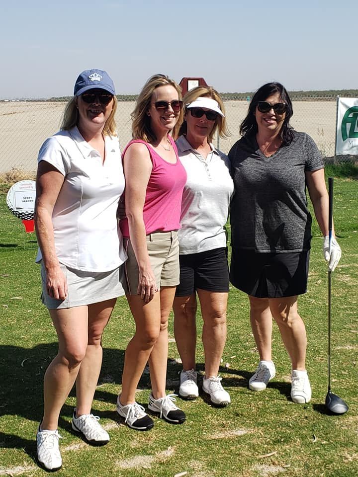 A group of women are posing for a picture on a golf course.