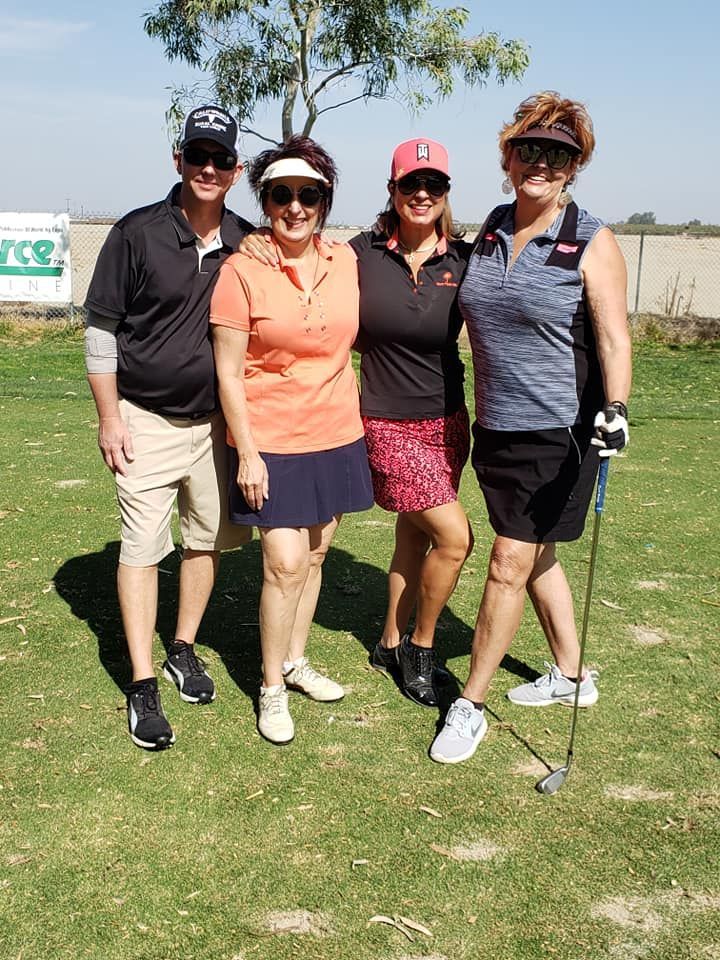 A group of people are posing for a picture on a golf course.