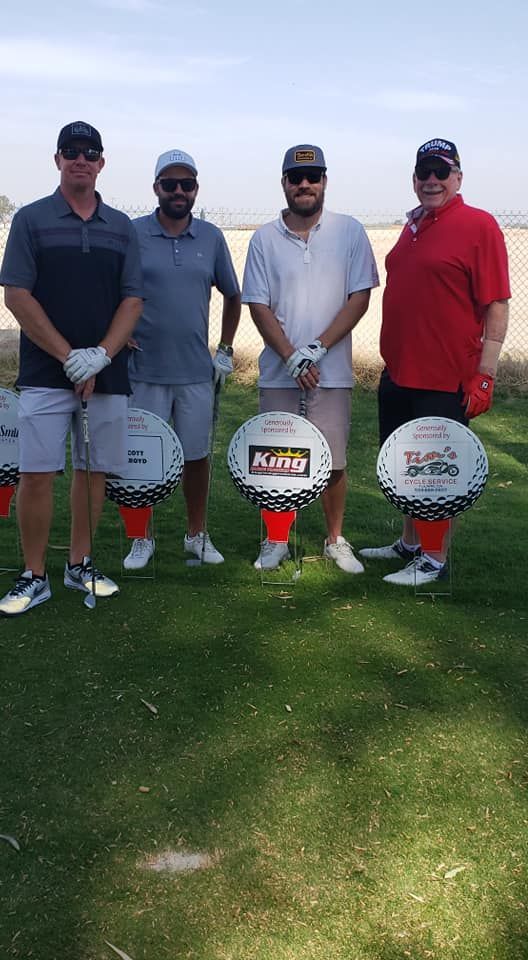 A group of men are standing on a golf course holding golf clubs.
