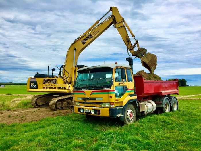 20 ton Komatsu digger carting topsoil in Southland