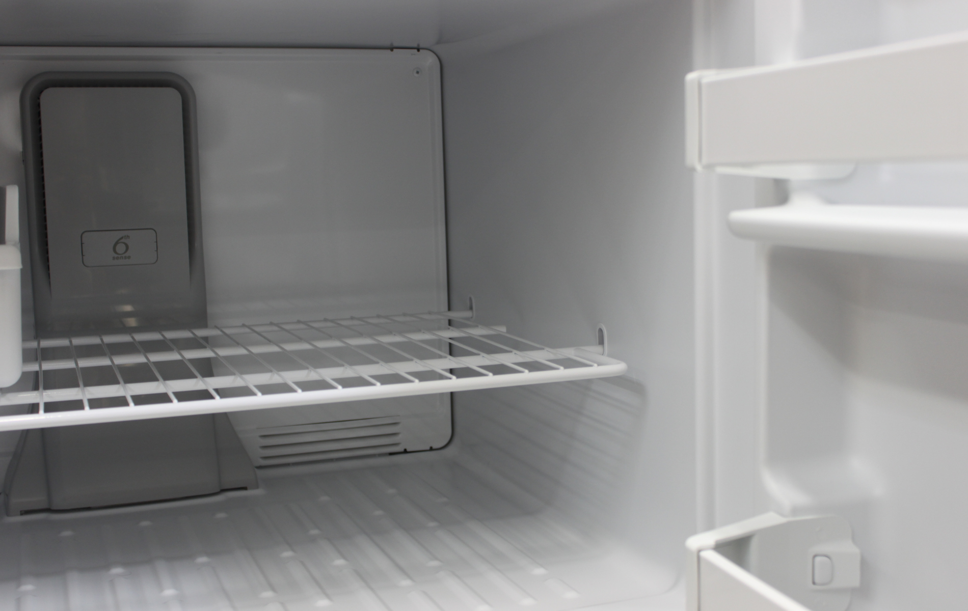 The inside of an empty refrigerator with the door open.