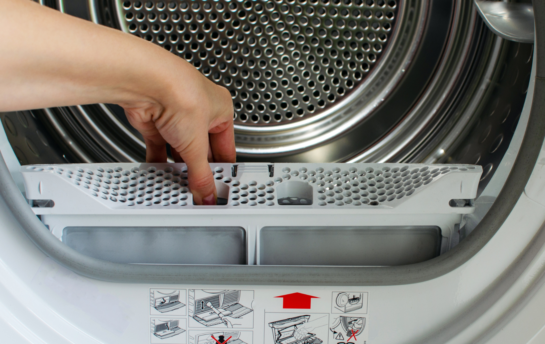 A person is opening the door of a washing machine.