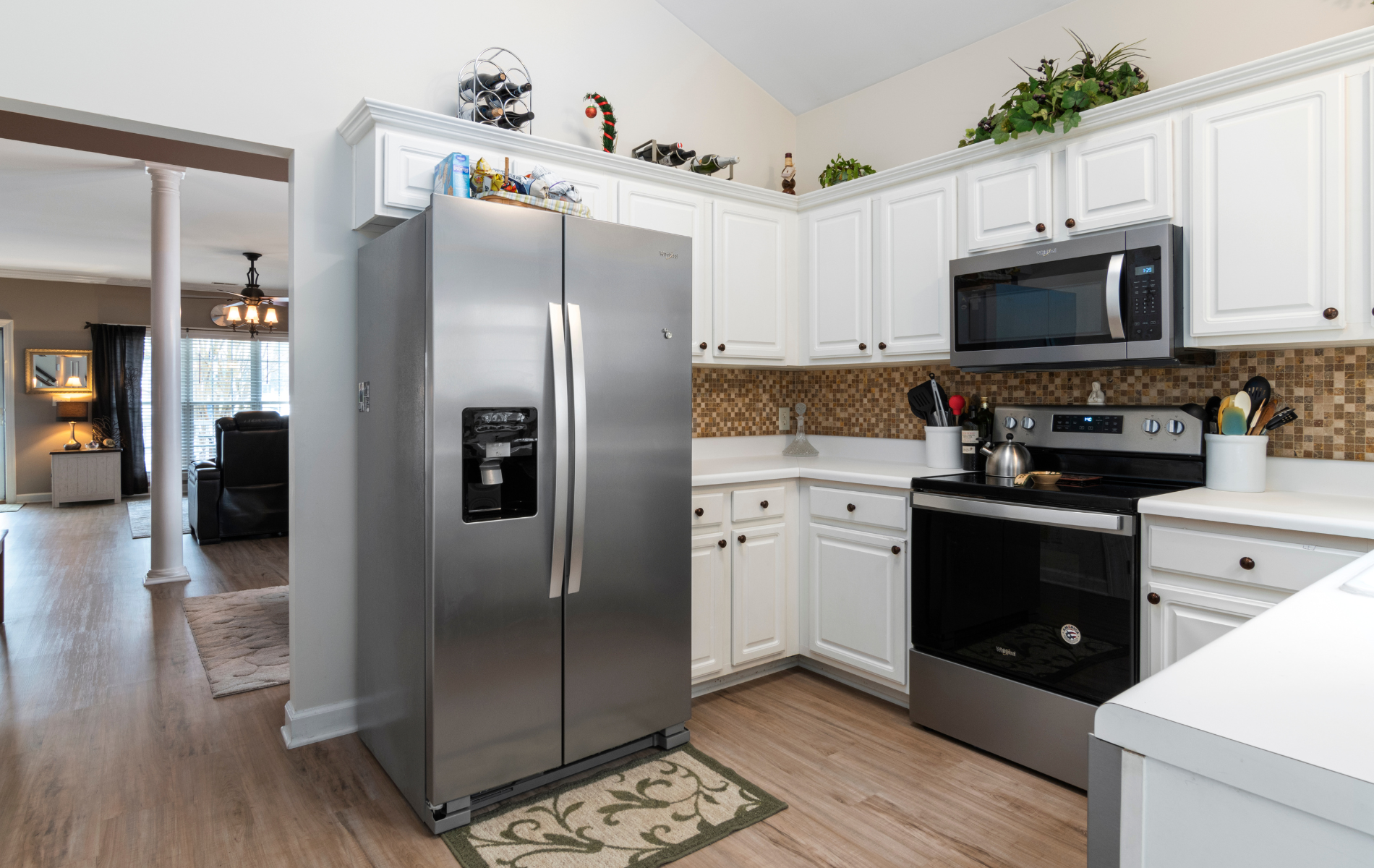 A kitchen with stainless steel appliances and white cabinets.