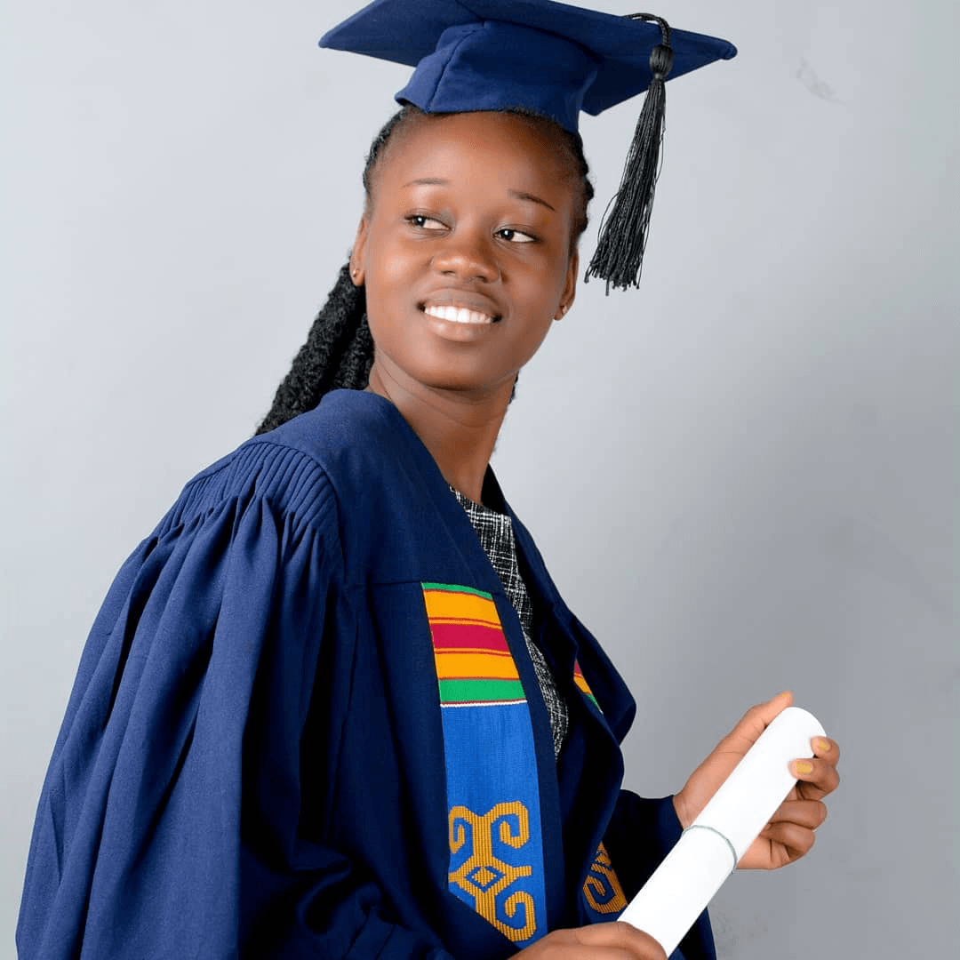 Femme en toque et robe de remise de diplôme, souriante, tenant son diplôme.
